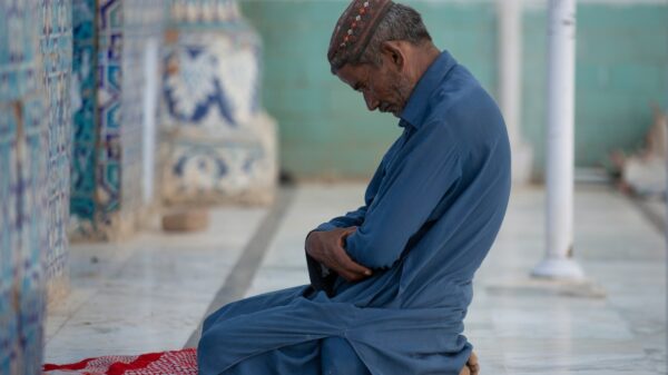 a man sitting on the ground with his hands in his pockets